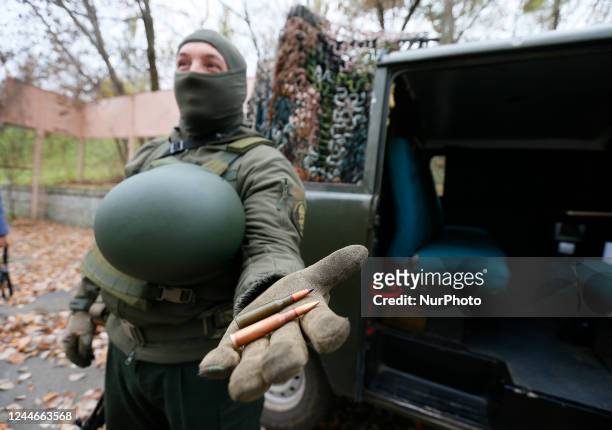 An Ukrainian serviceman of National Guard shows ammunition as he stands next to a homemade anti-aircraft machine gun to destroy drones presented in...