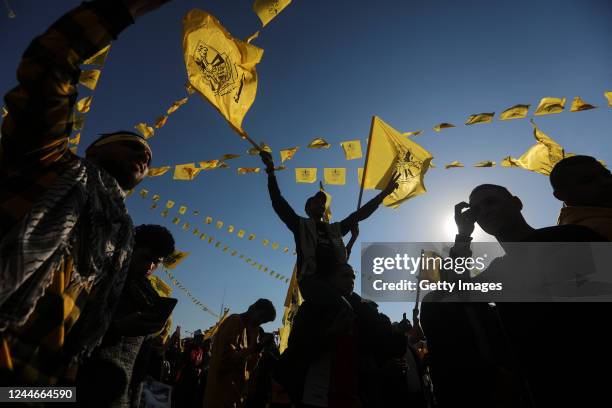 Palestinian youth waves Fatah movement's flag during a festival marking the 18th anniversary of the death of the late Palestinian Authority President...