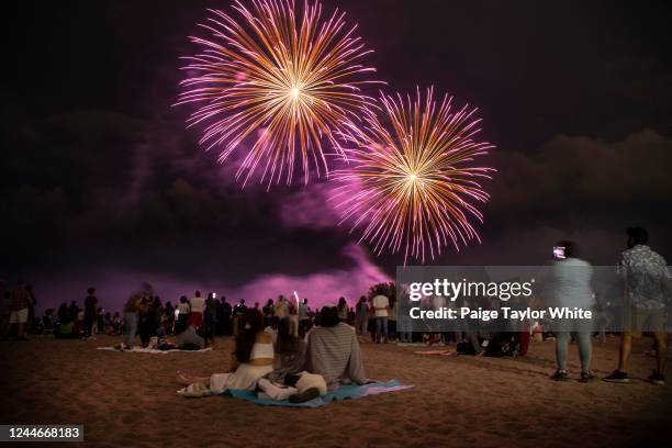 People gather at Woodbine Beach to watch Canada Day fireworks over Ashbridges Bay in Toronto