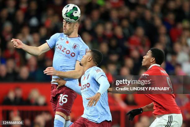 Manchester United's French striker Anthony Martial watches as Aston Villa's English defender Calum Chambers headers the ball during the English...