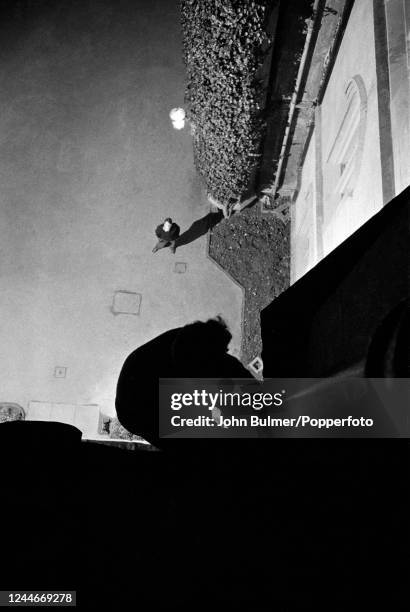 Student, watched by another, night climbing on one of the historic buildings at Cambridge University, England, circa June 1959. Night climbing...