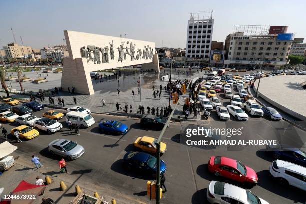 This picture shows traffic in Baghdad's Tahrir Square with the iconic Freedom Monument, a 50-metre long bas relief that honours the 1950 revolution...