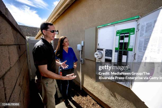 Menifee, CA Scott Hensen, vice president of floor planning for KB Home, left, shows a Square D energy center smart panel outside a model home during...