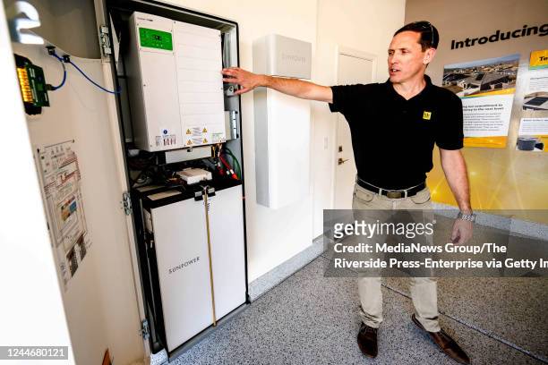 Menifee, CA Scott Hensen, vice president of floor planning for KB Home, shows a solar energy battery storage unit by SunPower inside the garage of a...