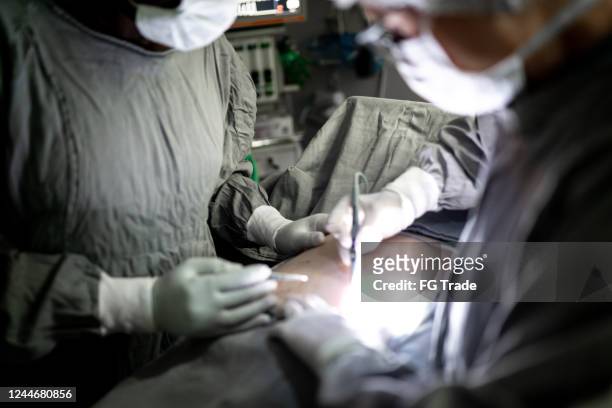 doctors doing a surgery on operating room in hospital - liposuction stock pictures, royalty-free photos & images