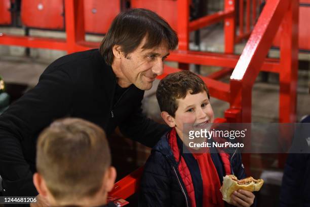 Antonio Conte, manager of Tottenham Hotspur poses for a photo with young Forest supporters during the Carabao Cup Third Round match between...