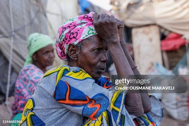 Woman sits outside a makeshift shelter at the Faladie internally displaced people camp in Bamako on November 9, 2022. - People fleeing a decade-long...