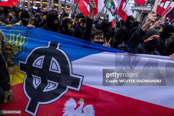 Celtic Cross is seen on a banner with the Polish and Ukrainian national colours as participants attend the country's Independence Day march organised...