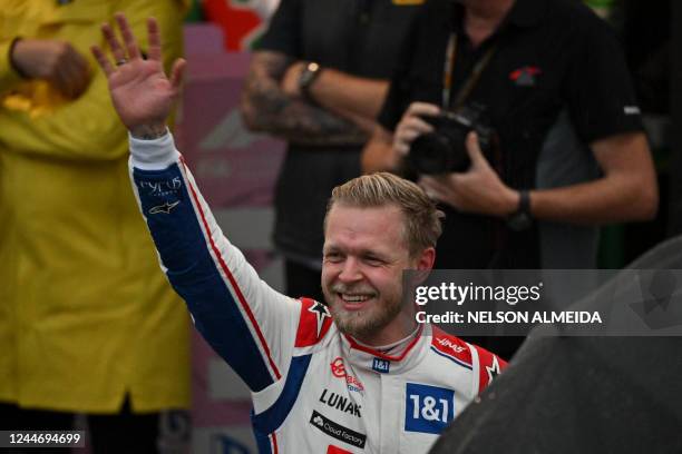 Haas F1 Team's Danish driver Kevin Magnussen celebrates after winning the qualifying session at the Autodromo Jose Carlos Pace racetrack, also known...