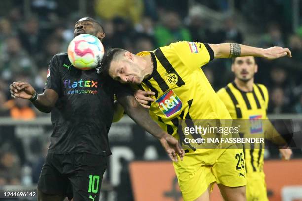 Moenchengladbach's French forward Marcus Thuram and Dortmund's German defender Niklas Suele vies for the ball during the German first division...