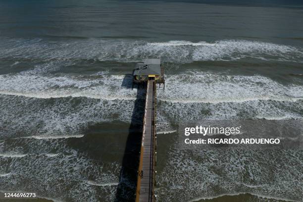 Waves crash into the pier at Daytona Beach, Florida, in the aftermath of Hurricane Nicole on November 11, 2022. The rare late storm sparked mandatory...