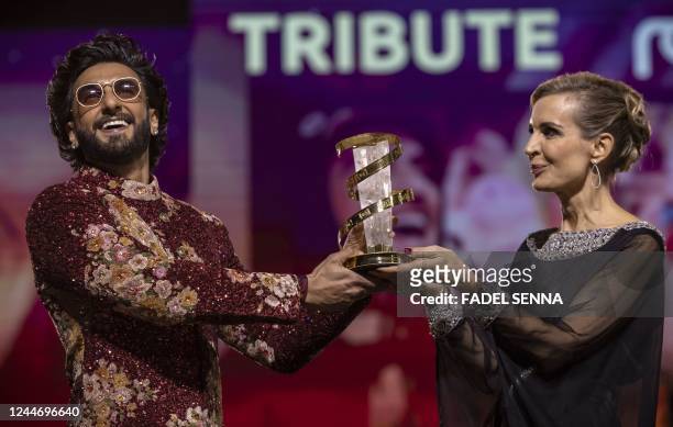 India's actor Ranveer Sinch receives a tribute trophee from French actress Melita Toscan du Plantier during the opening ceremony of the 19th...