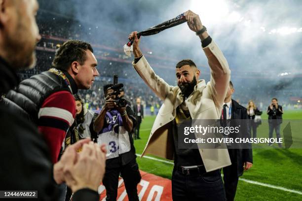 Real Madrid's French forward Karim Benzema gestures to fans during the presentation of his Ballon d'Or trophy at half time of the French L1 football...