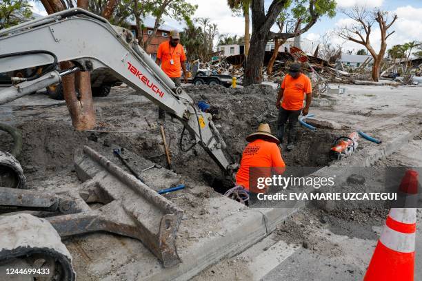 Construction workers try estore services in Fort Myers Beach, Florida, on November 2 after Hurricane Ian devastated the area on September 28, 2022. -...