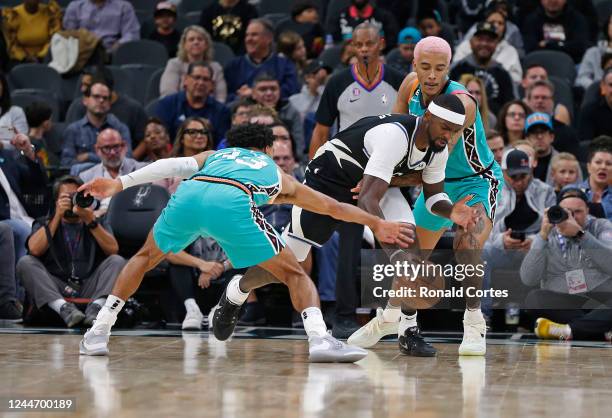 Bobby Portis of the Milwaukee Bucks is pressured by Tre Jones of the San Antonio Spurs and Jeremy Sochan in the first half at AT&T Center on November...