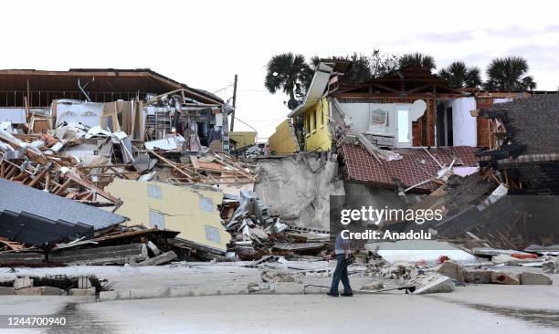 Man walks past homes that collapsed onto the beach due to the storm surge and resulting erosion caused by Hurricane Nicole on November 11, 2022 in...