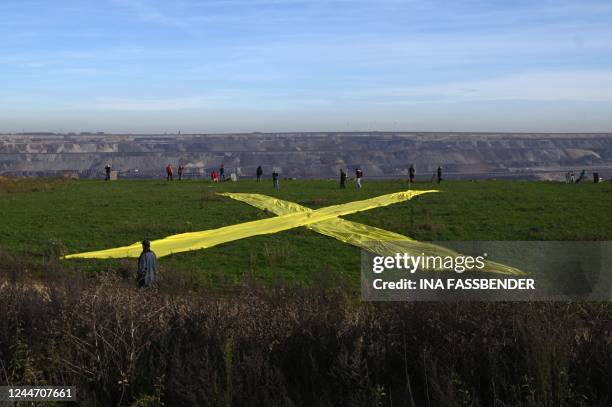 Activists have laid out a yellow diagonal cross, the symbol of resistance against coal mining and coal firing, during a demonstration at the...