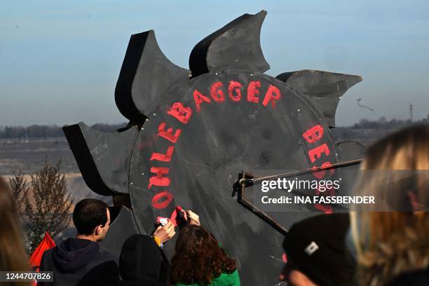 Protesters write "Occupy Coal Diggers" on a mock-up of a bucket wheel excavator during a demonstration at the Garzweiler lignite open cast mine near...