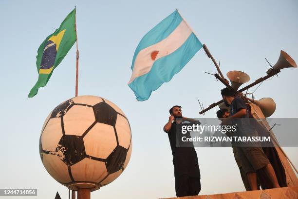 Football fans install flags of Brazil and Argentina ahead of Qatar 2022 FIFA World Cup football tournament on the rooftop of a house in Karachi on...