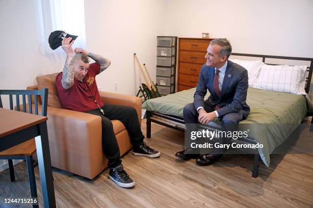 Chris Reynolds left, a musician now studying shipping and logistics, recently moved into a studio apartment, visits with Mayor Eric Garcetti, at...