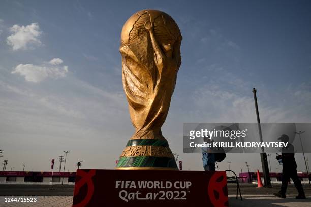 Men walk past a FIFA World Cup trophy replica outside the Ahmed bin Ali Stadium in Al-Rayyan on November 12 ahead of the Qatar 2022 FIFA World Cup...