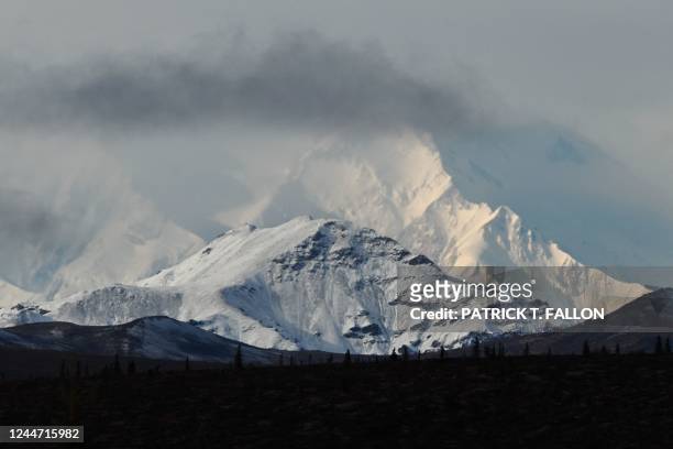 Clouds partially obscure Denali, the highest mountain peak in North America, as seen from inside Denali National Park, Alaska, on September 22, 2022.