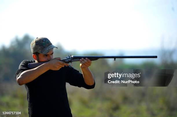 Hunter shoots a wolf during The fishing season began in Tunisia at the city of El-Battan 38 km west of Tunis. In a forest near an abstract river...