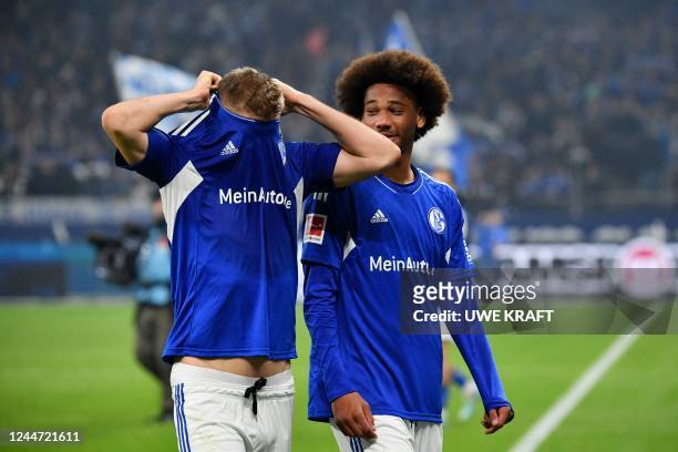 Schalke's German forward Simon Terodde reacts next to team mate Schalke's German midfielder Sidi Sane at the end of the German first division...