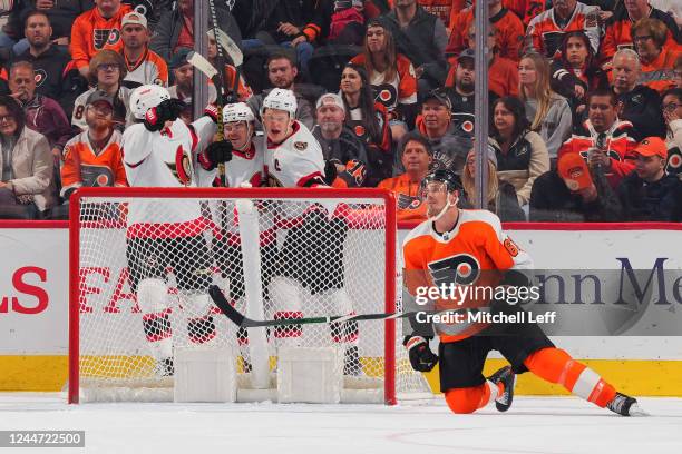 Alex DeBrincat of the Ottawa Senators celebrates his goal with Drake Batherson and Brady Tkachuk in front of Justin Braun of the Philadelphia Flyers...