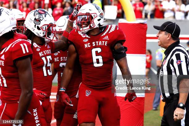 Trent Pennix of the North Carolina State Wolfpack celebrates his 27-yard touchdown with teammate Keyon Lesane during the first half against the...
