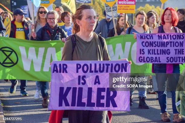 Protester holds a banner which states 'Air pollution is a killer' during the demonstration on Waterloo Bridge. Thousands of people gathered outside...