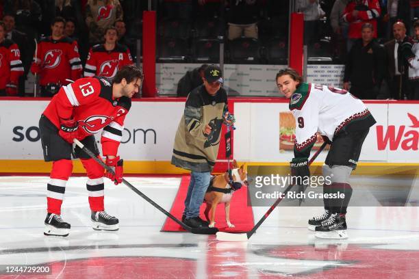 Army Veteran Dawn Amato and her service dog Peaches drop the ceremonial puck to Nico Hischier of the New Jersey Devils and Clayton Keller of the...