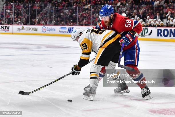 David Savard of the Montreal Canadiens defends against Jake Guentzel of the Pittsburgh Penguins during the first period of the game at Centre Bell on...
