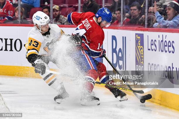 Nick Suzuki of the Montreal Canadiens and Danton Heinen of the Pittsburgh Penguins skate after the puck during the second period of the game at...