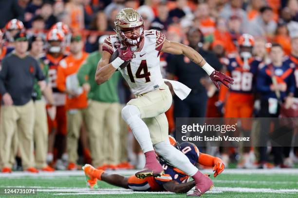 Johnny Wilson of the Florida State Seminoles evades a tackle by Darian Chestnut of the Syracuse Orange during the game at JMA Wireless Dome on...