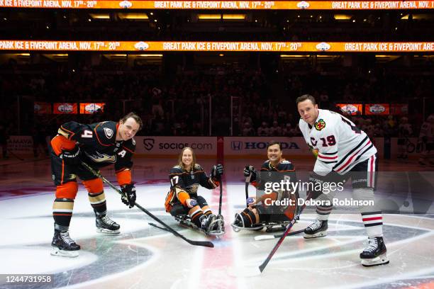 Cam Fowler of the Anaheim Ducks and Jonathan Toews of the Chicago Blackhawks pose for a ceremonial puck drop with Anaheim Ducks Sled Hockey player...