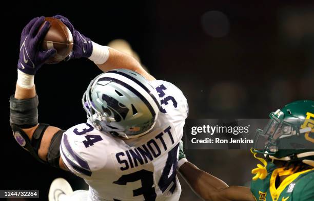 Ben Sinnott of the Kansas State Wildcats catches a touchdown pass as Christian Morgan of the Baylor Bears defends in the second half of the game at...