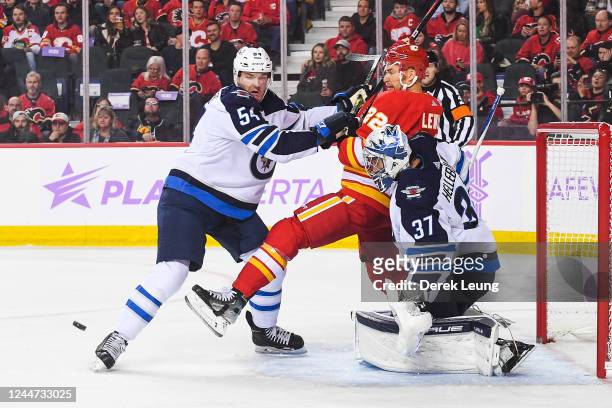 Dylan Samberg and Conner Hellebuych of the Winnipeg Jets defend net against Trevor Lewis of the Calgary Flames during the first period of an NHL game...