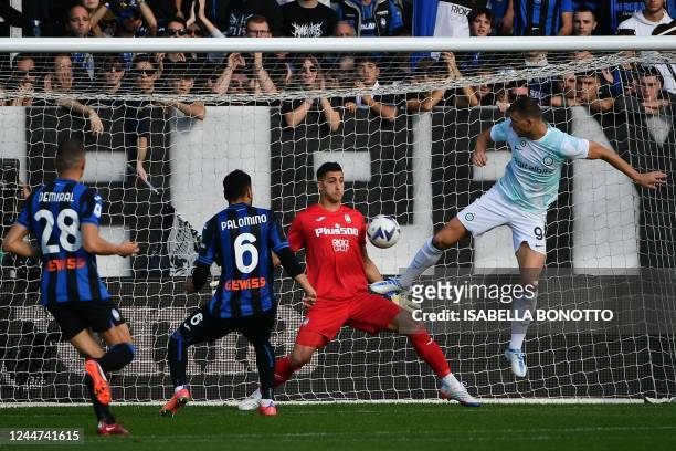 Inter Milan's Bosnian forward Edin Dzeko scores an equalizer past Atalanta's Argentinian goalkeeper Juan Musso during the Italian Serie A football...