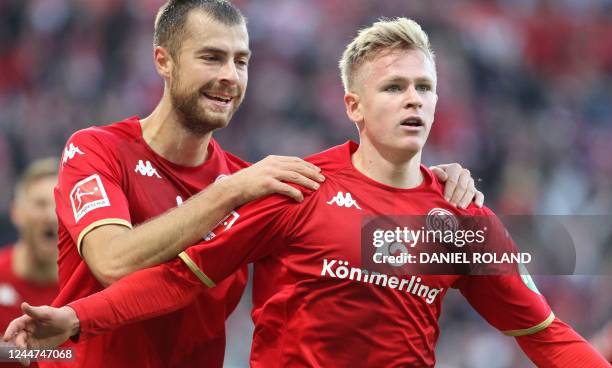 Mainz' German forward Jonathan Burkardt celebrates with Mainz' German defender Alexander Hack after scoring the 1-0 goal during the German first...