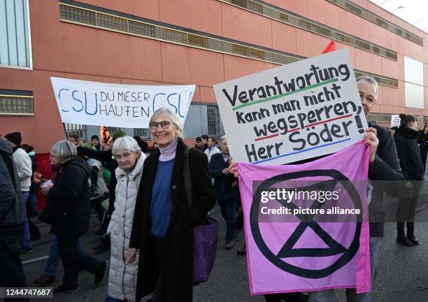 November 2022, Bavaria, Munich: Demonstrators holding placards reading "Responsibility can't be locked away, Mr. Söder!" and "CSU, you rotten bunch"...