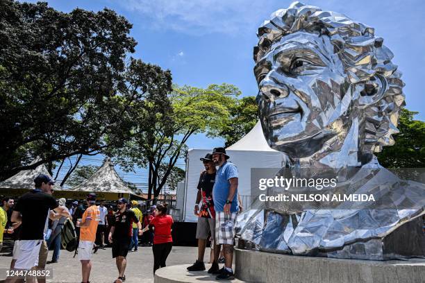 Fans pose for a picture in front of an sculpture of late Brazilian F1 driver Ayrton Senn at the Autodromo Jose Carlos Pace racetrack, also known as...