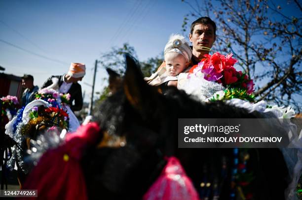 Member of the Muslim community holds his son on a horse during a procession, as part of a circumcision ceremony for young boys in the village of...