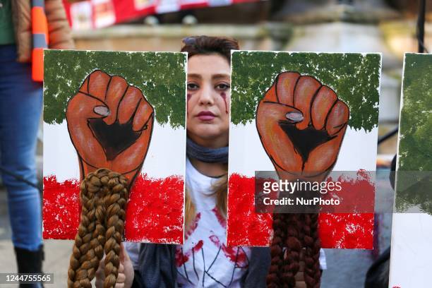 Woman holds signs with womens hair during a demonstration in honor of Jina Mahsa Amini and the other protesters killed under the orders of the...