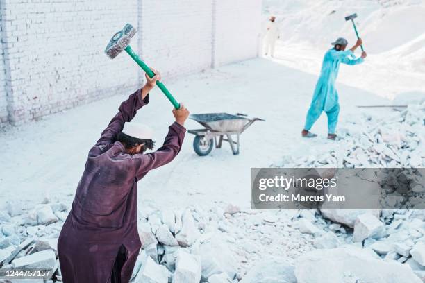 Man breaks down marble deposits at a processing center in Jalalabad, Afghanistan, Sunday, Sept. 11, 2022.