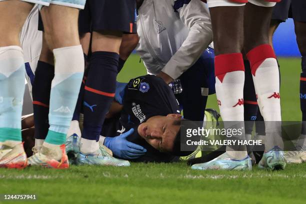 Marseille's Moroccan midfielder Amine Harit reacts in pain after suffering an injury during the French L1 football match between AS Monaco and...