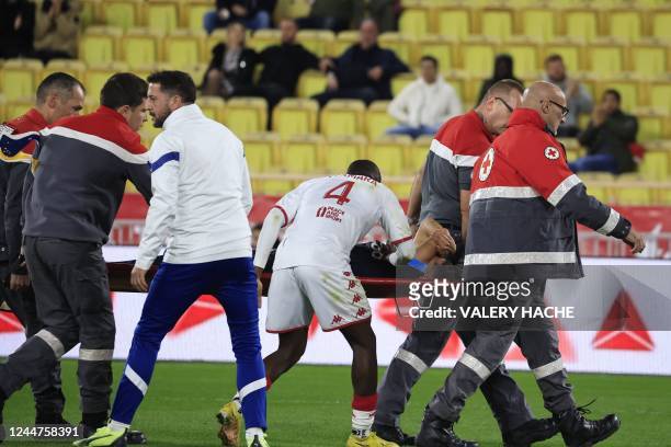 Marseille's Moroccan midfielder Amine Harit is comforted by Monaco's Malian midfielder Mohamed Camara as he is evacuated on a stretcher after...