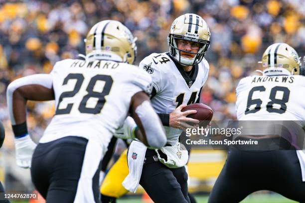 New Orleans Saints quarterback Andy Dalton looks to hand the ball off to New Orleans Saints running back Jordan Howard during the national football...