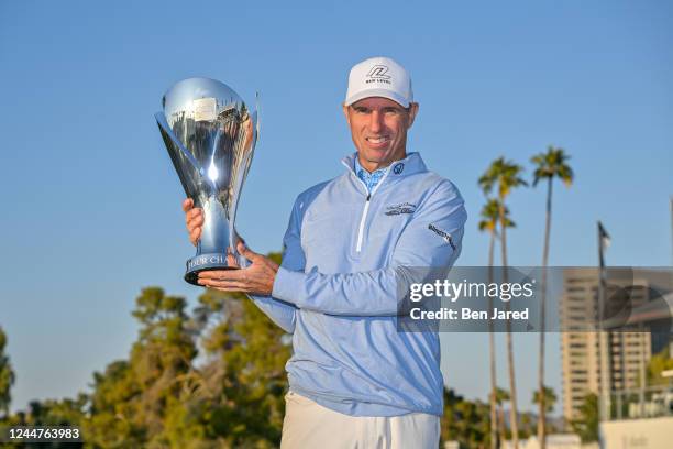 Steven Alker of New Zealand holds the Charles Schwab Cup on the 18th green after the final round of the PGA TOUR Champions Charles Schwab Cup...