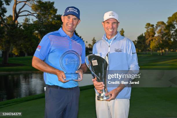 Steven Alker of New Zealand and Pádraig Harrington of Ireland stand together with the Charles Schwab Cup and the tournament trophy on the 18th green...